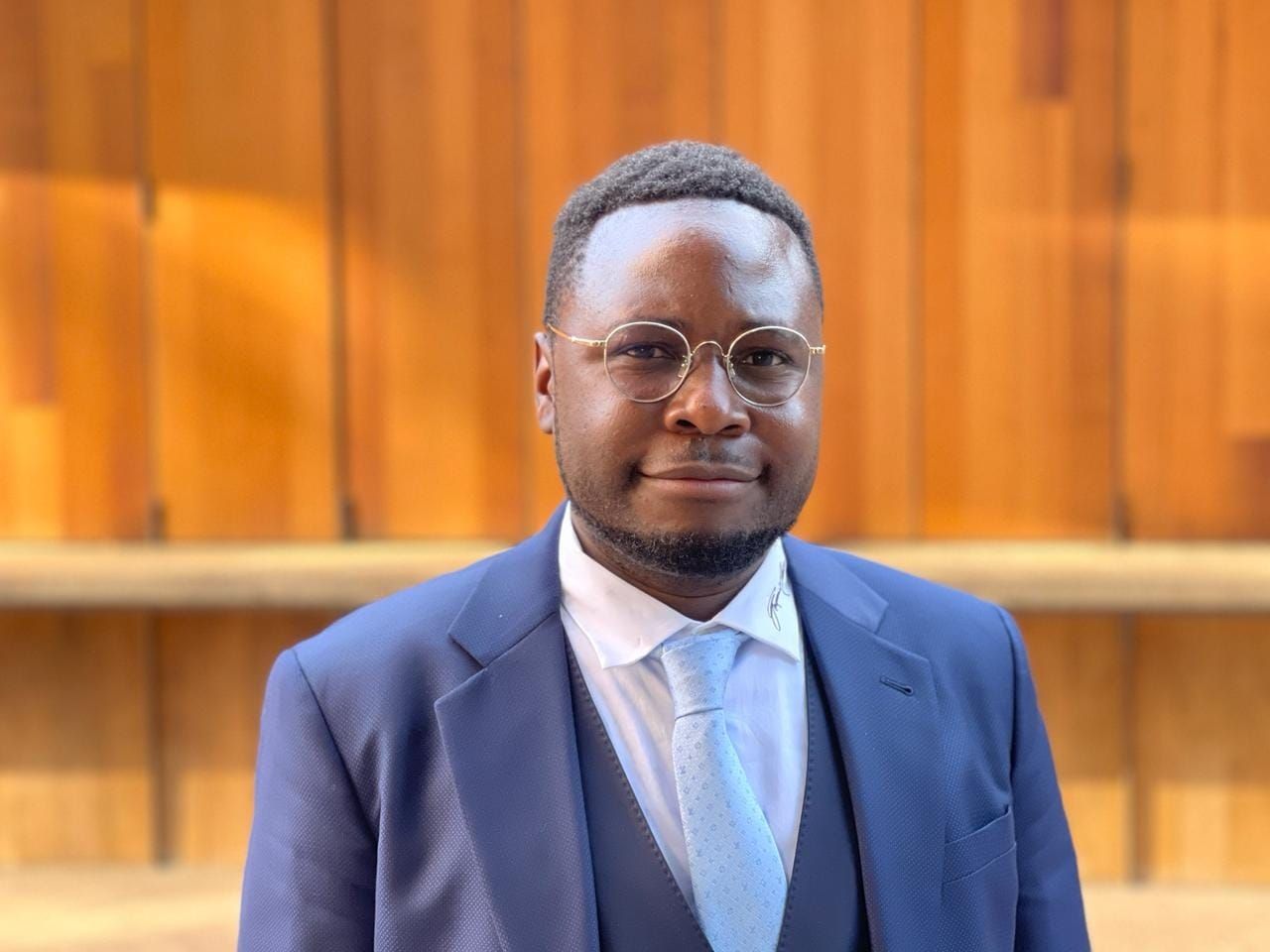 Ian Balina in a navy suit and glasses